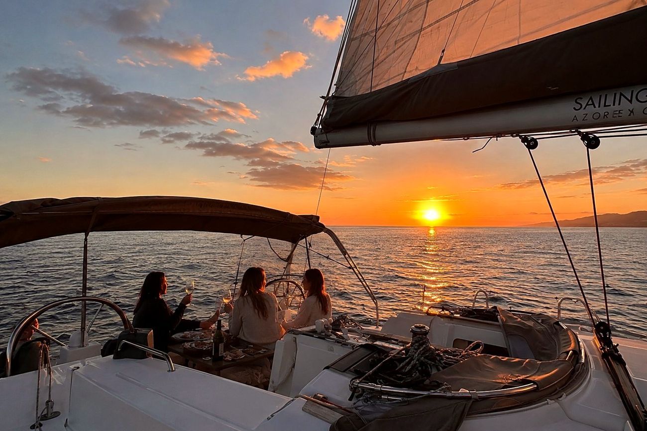 Friends waving from a sailing yacht at sunset, Azores ocean